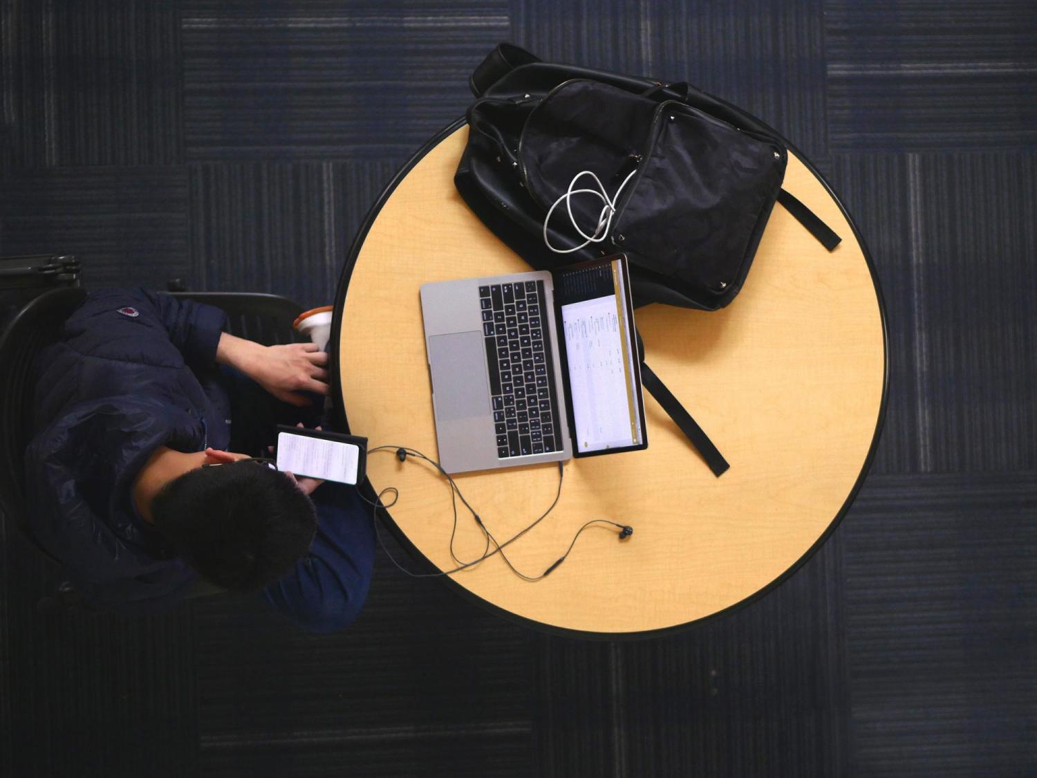Student with phone and laptop