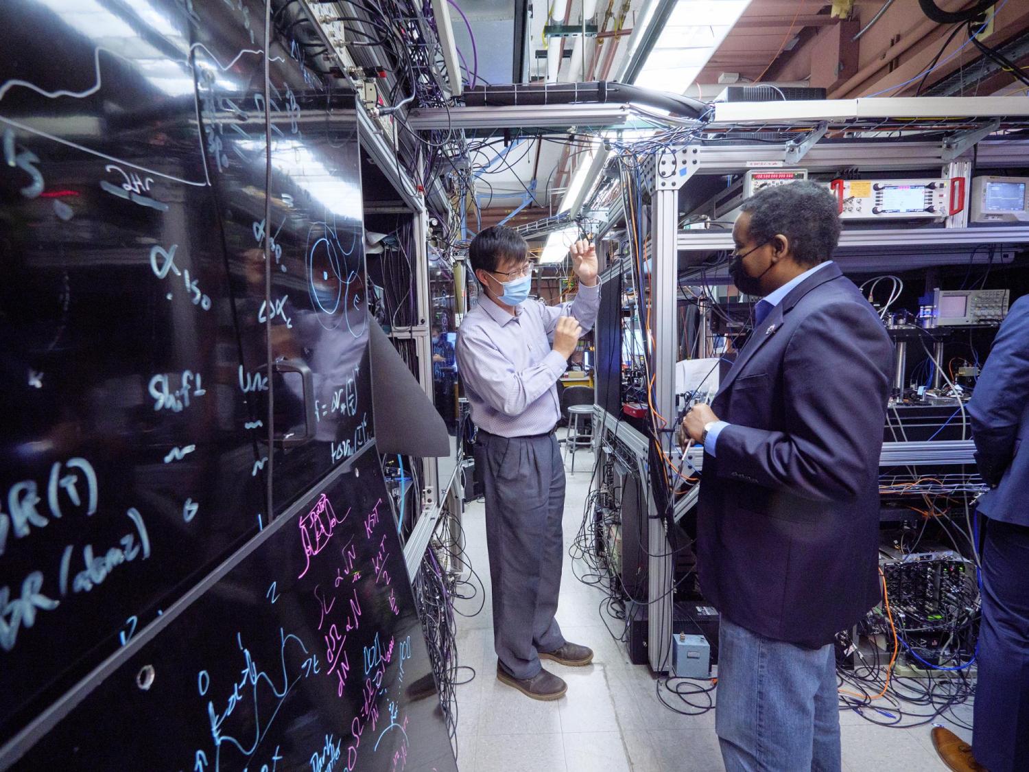 Physicist Jun Ye gives U.S. Rep. Joe Neguse a tour of his lab at JILA on the CU Boulder campus.