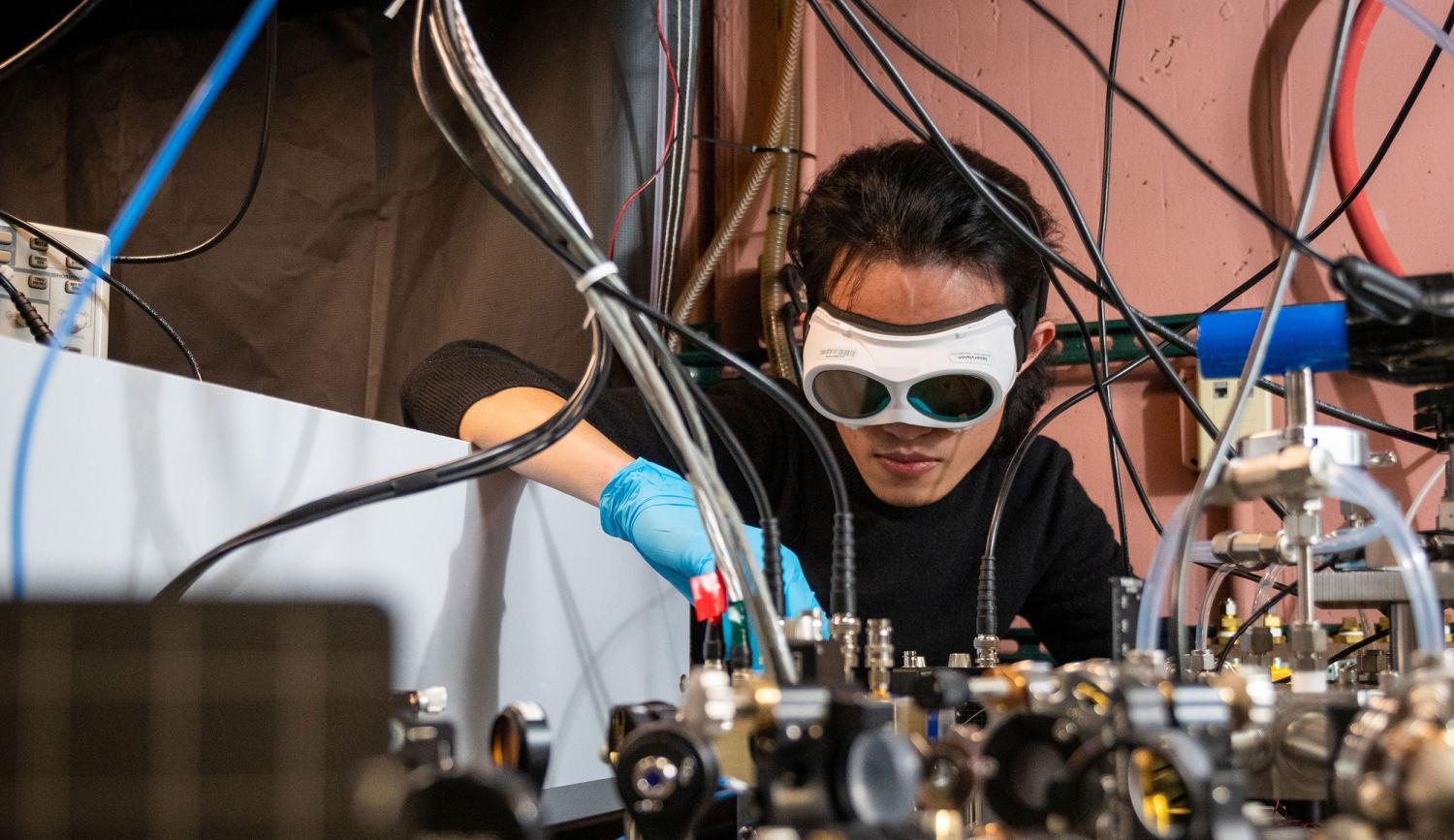 Qizhong Liang, a PhD candidate in JILA and the Department of Physics, demonstrates how the laser-based breathalyzer works, in the Ye lab at JILA.