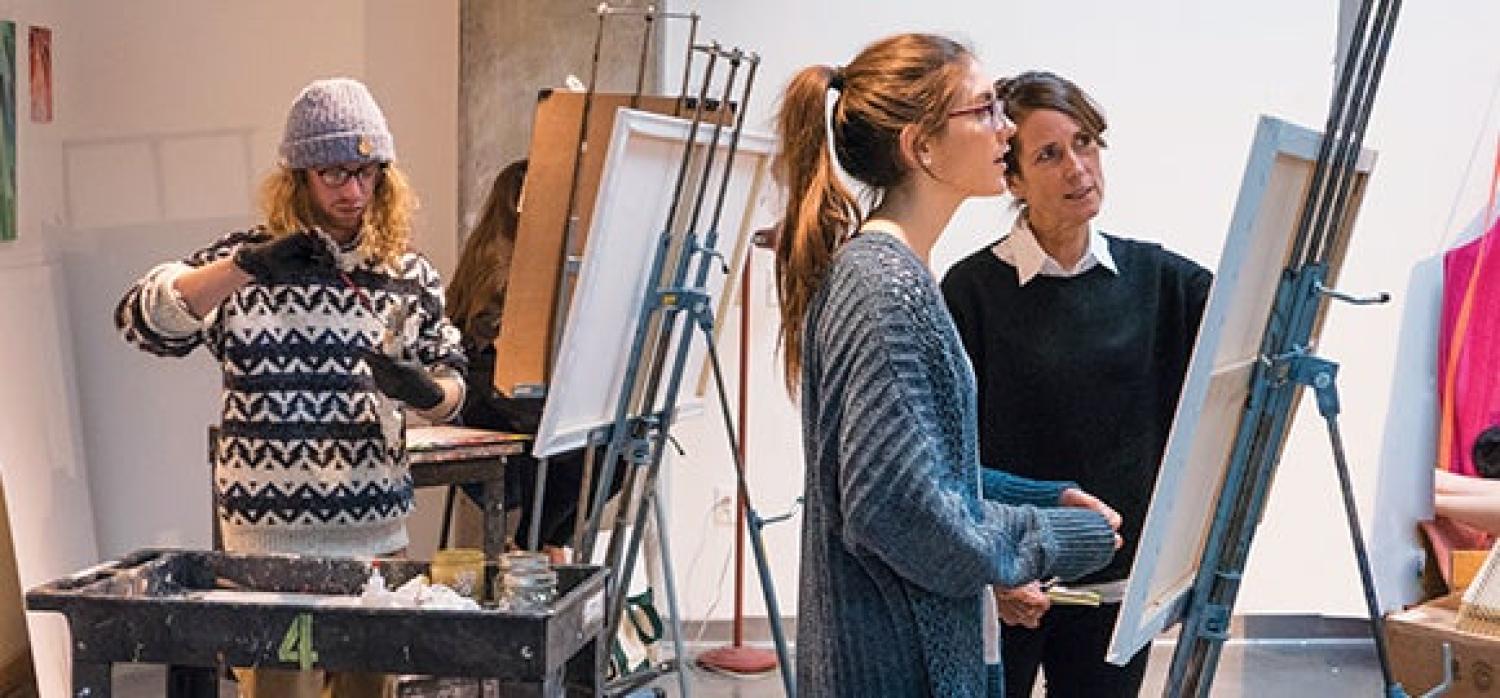 An art student receiving instruction from their professor