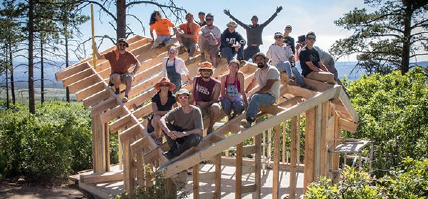Environmental Design students sitting atop a structure they built in the mountains