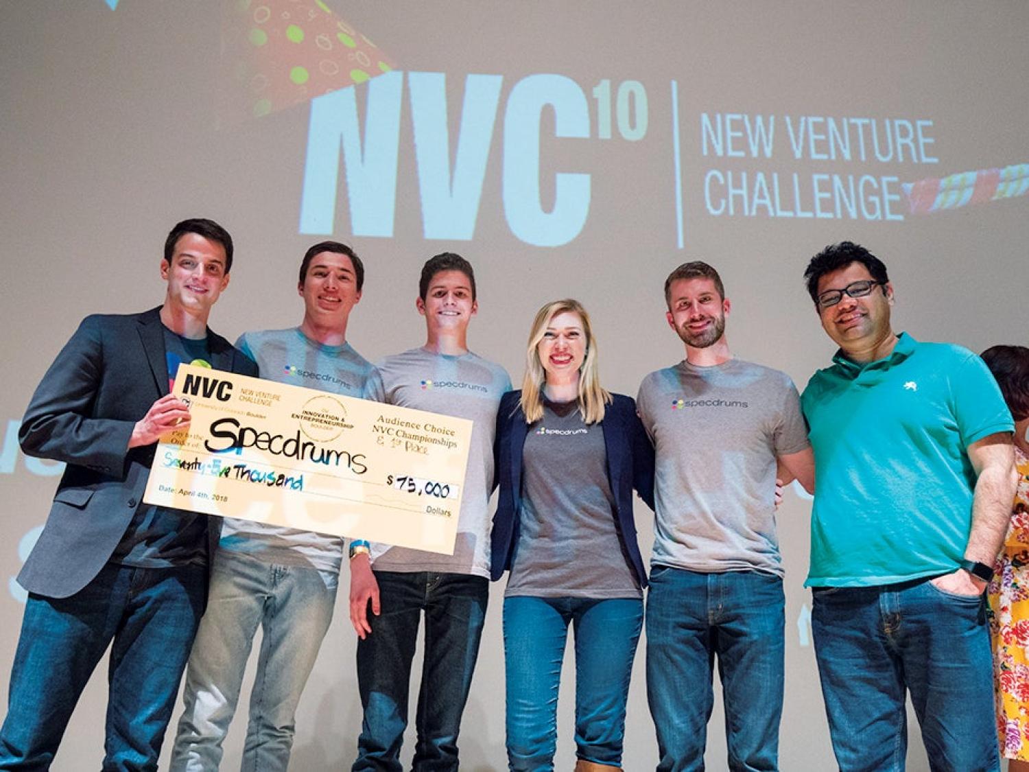Winning team on stage with prize check