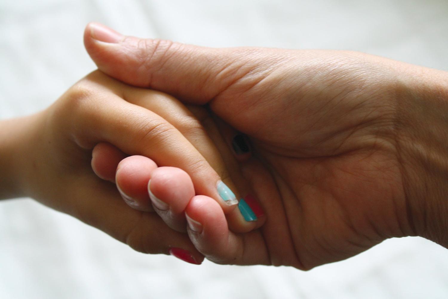Two hands holding one another
