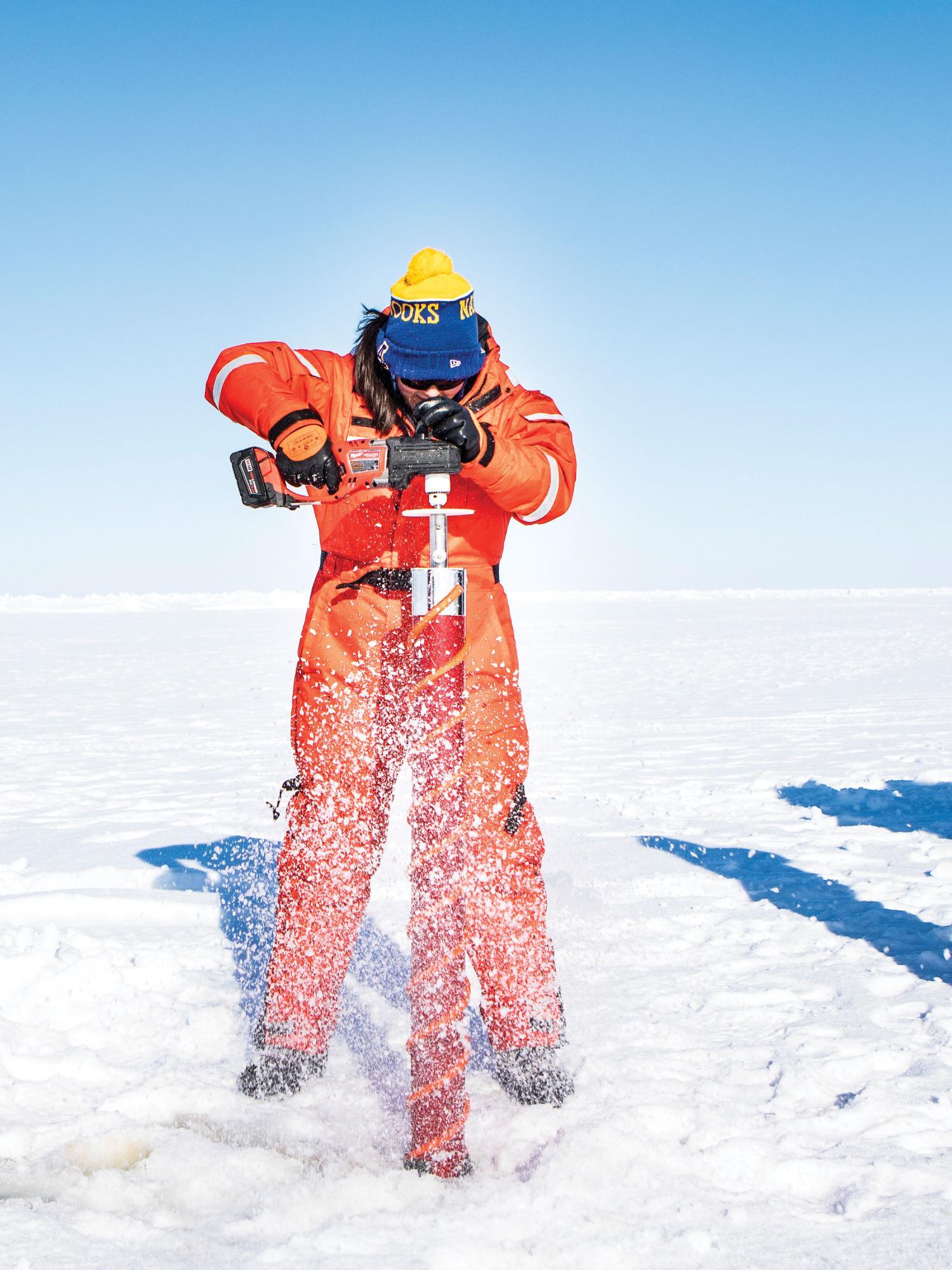 Researcher drilling ice in the arctic