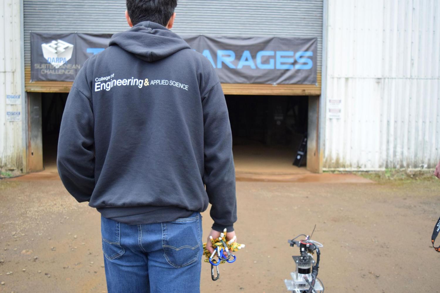 Back of student walking with robot