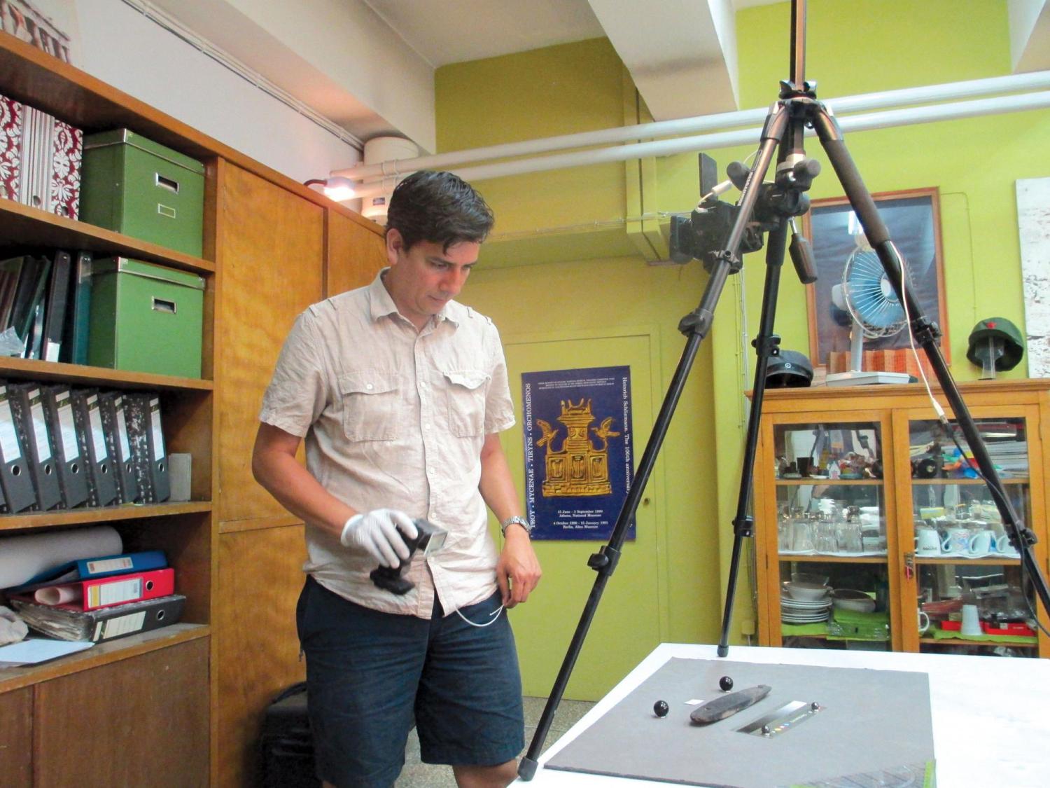 Dimitri Nakassis examining and photographing the pylos tablet
