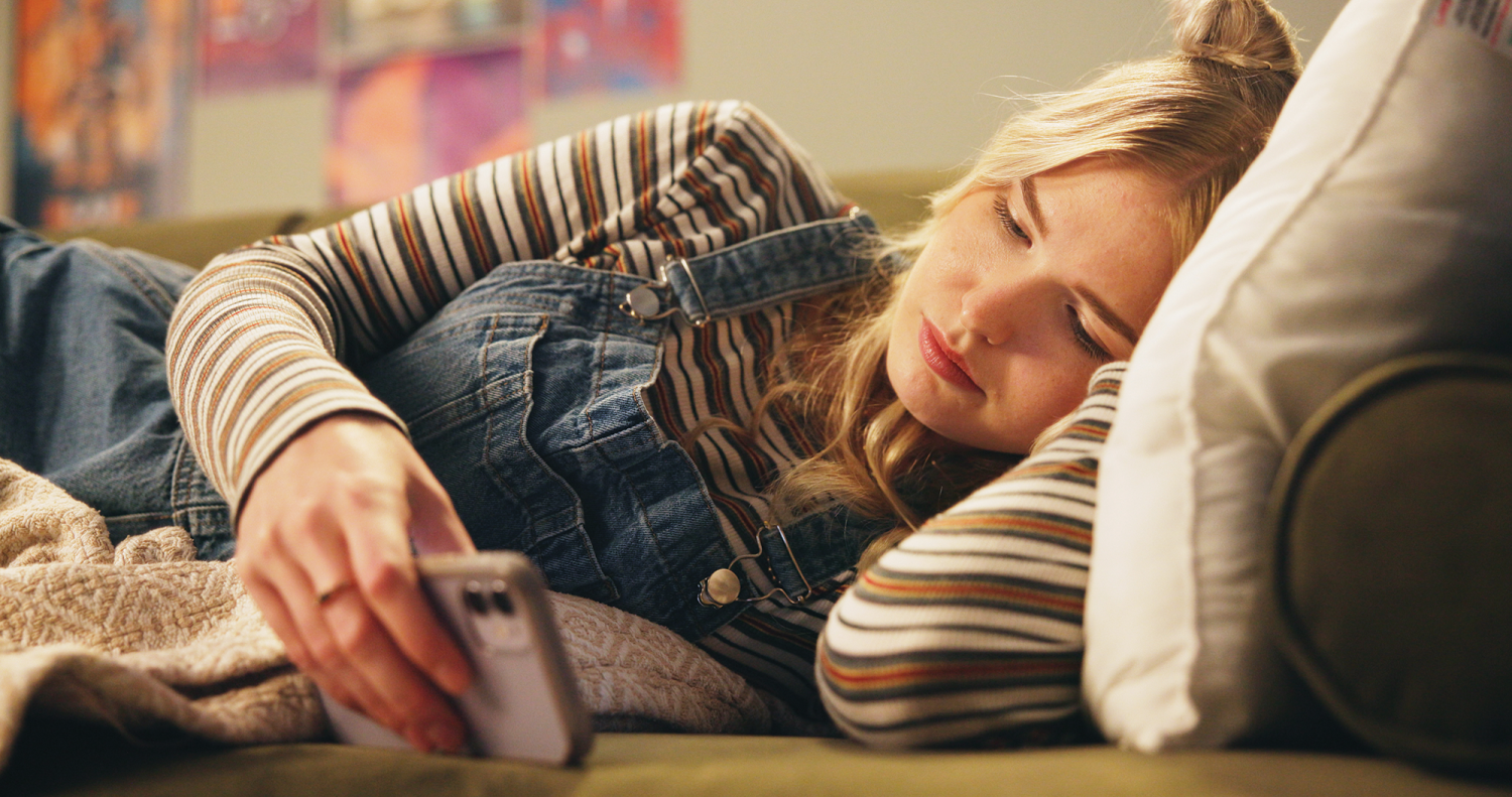 Teenage girl resting while checking her phone