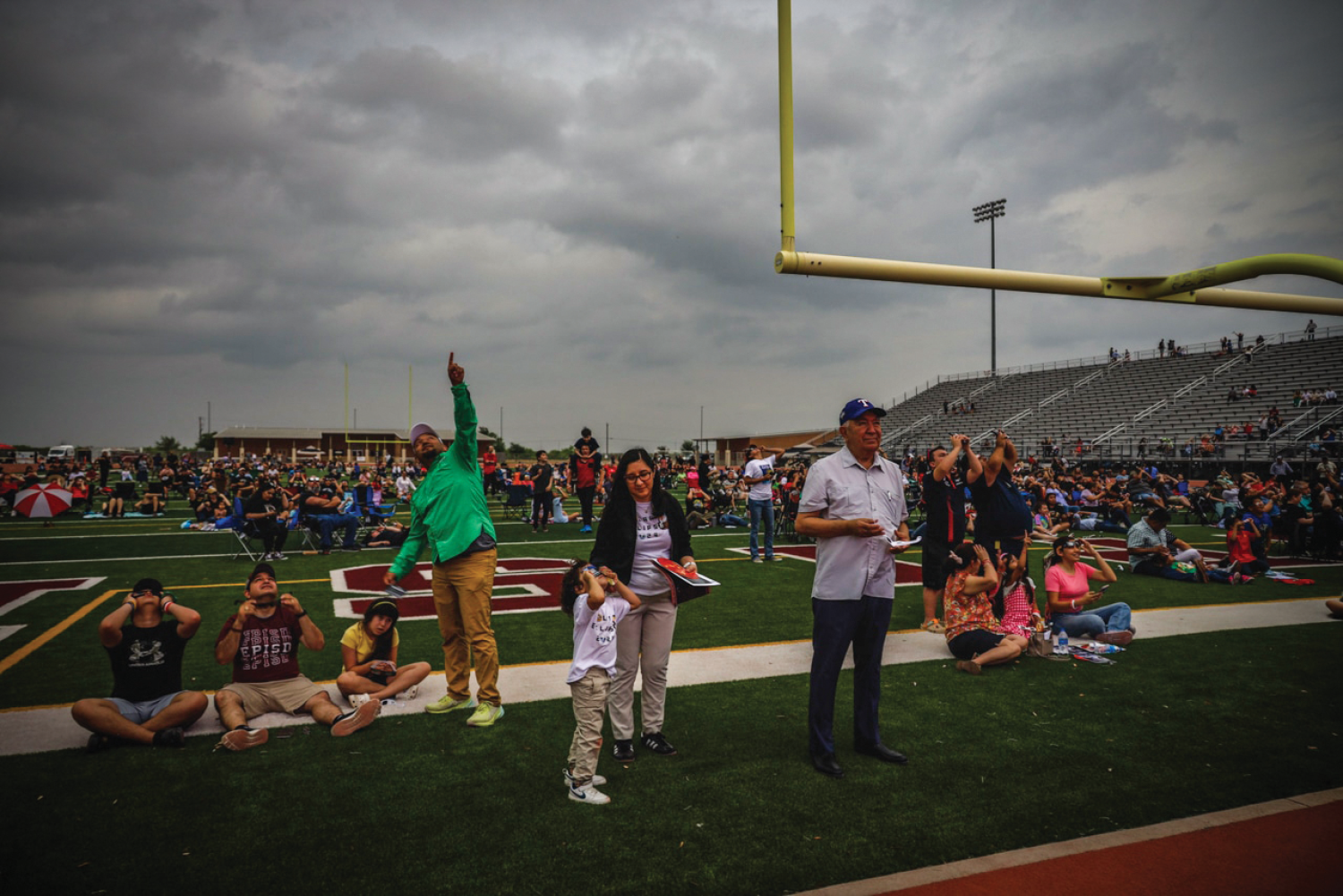 Skies darken and cheers roar as a partial eclipse looms