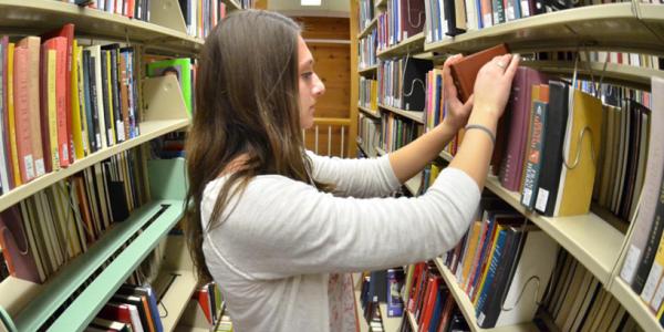 Girl searching through the library stacks