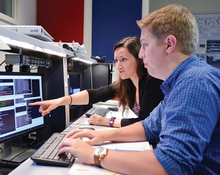 Graduate Research Assistants Sierra Flynn and Evan Graser getting hands-on space experience at LASP