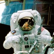 NASA astronaut services the Hubble Space Telescope from orbit in 1997