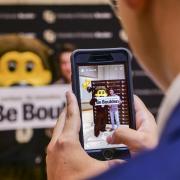 Parent taking students picture with CU Boulder sign