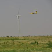 Tempest drone flying in front of a wind turbine