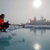 Scientist in the arctic with ship in the background