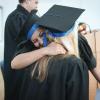 High school graduates hugging at graduation ceremony