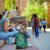 Student sitting on campus steps and looking at her phone