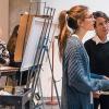 An art student receiving instruction from their professor