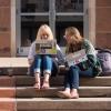 Students sitting outside on campus building steps