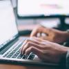 Student writing their college essay on a laptop