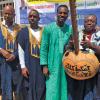 Researcher and colleagues in African garb with musical instrument