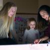 Researcher and children smiling at light table