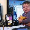 Mom holding baby with laptop in background