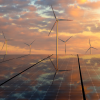 photovoltaic panels and wind turbines in the light of the rising sun