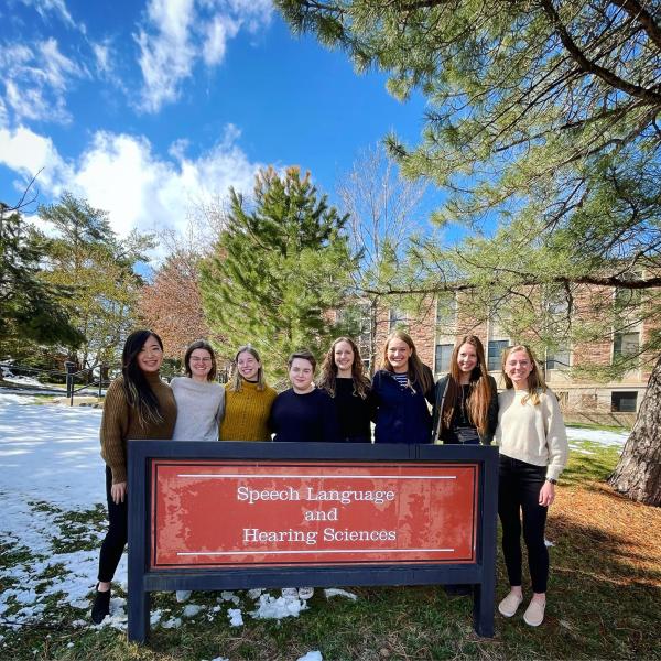 Some of the 2022 AuD students in front of the SLHS sign outside the SLHS building in the winter