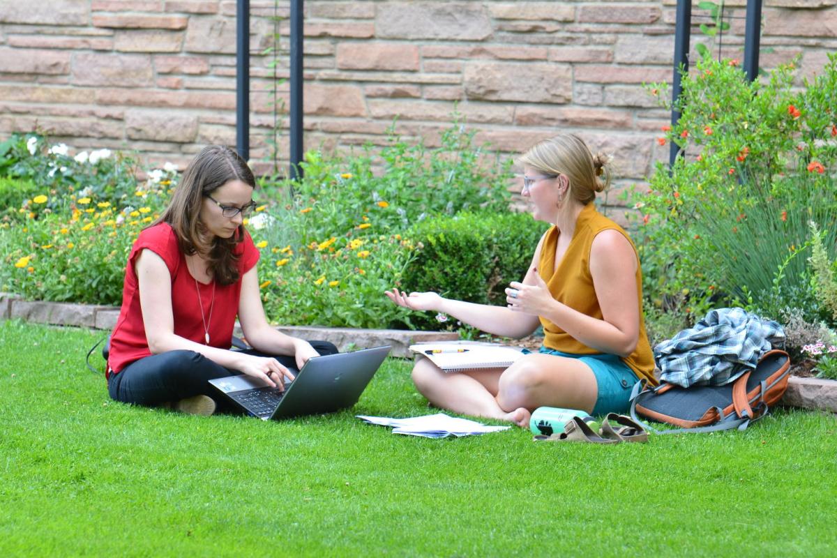Two women studying on ground