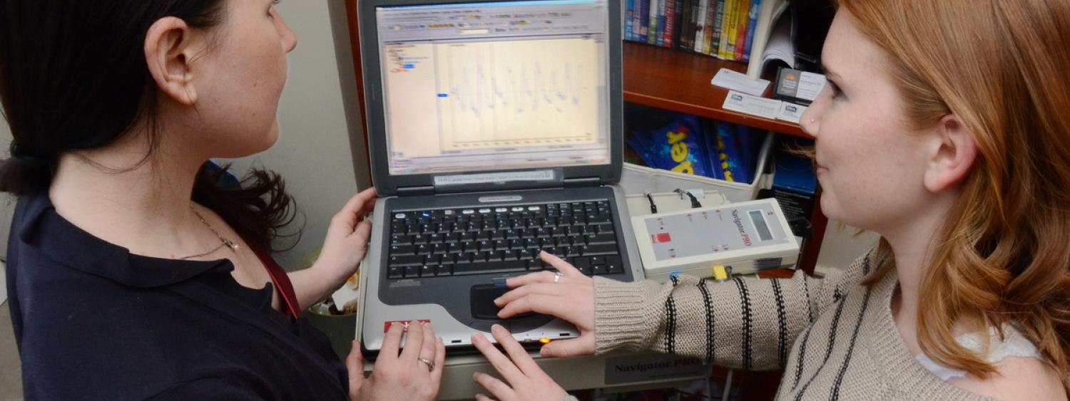 Students evaluating each other in front of a computer with results