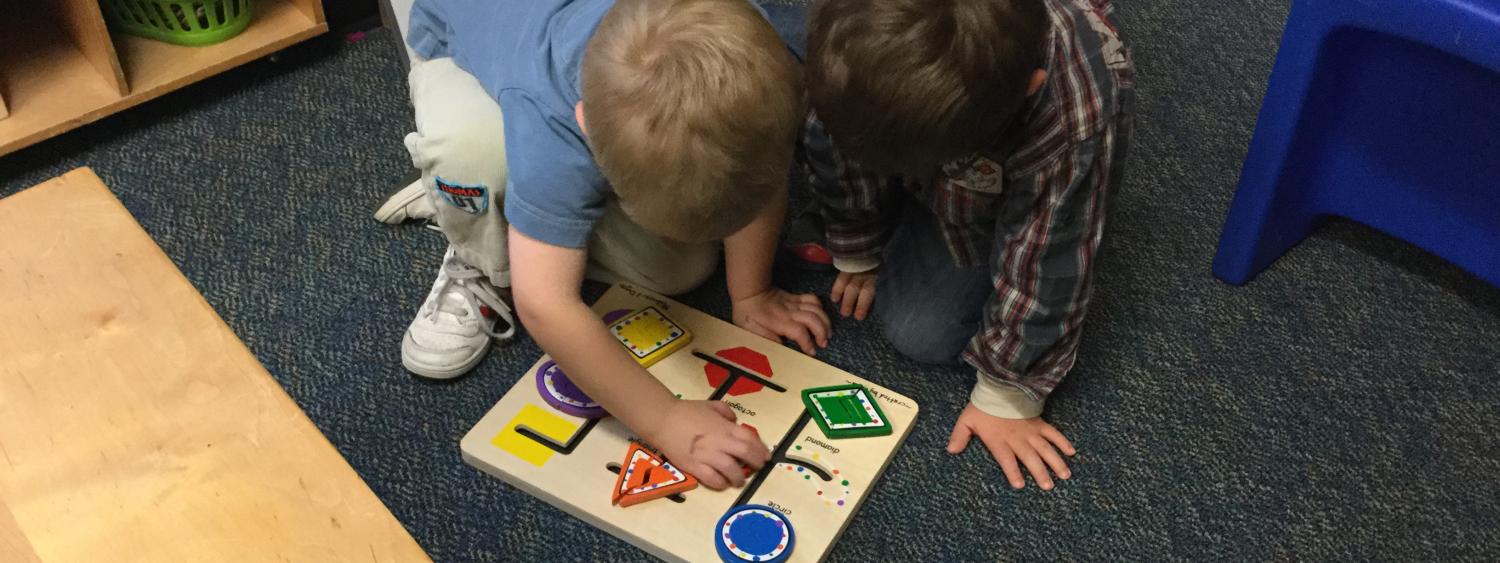 Two children working together to solve a puzzle