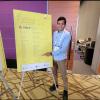 2nd Year MASLP student Tanvir Kalam in front of ASHA Poster