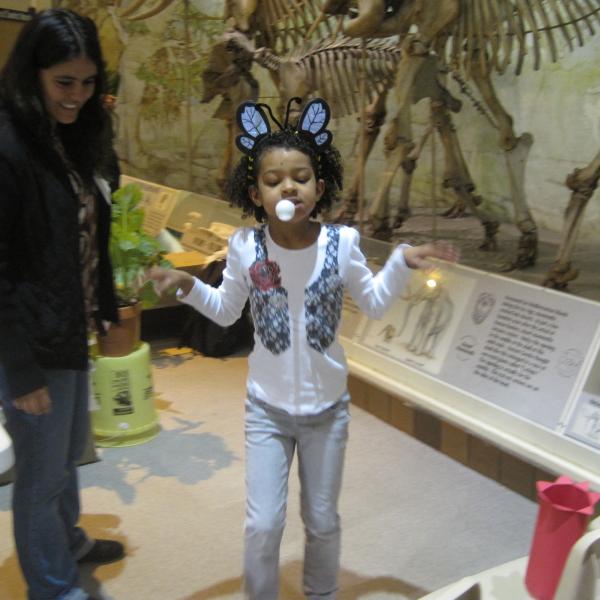 Daniela supervises an obstacle course in which "pollinators" attempt to drop their "pollen grain" into a paper flower for a prize.