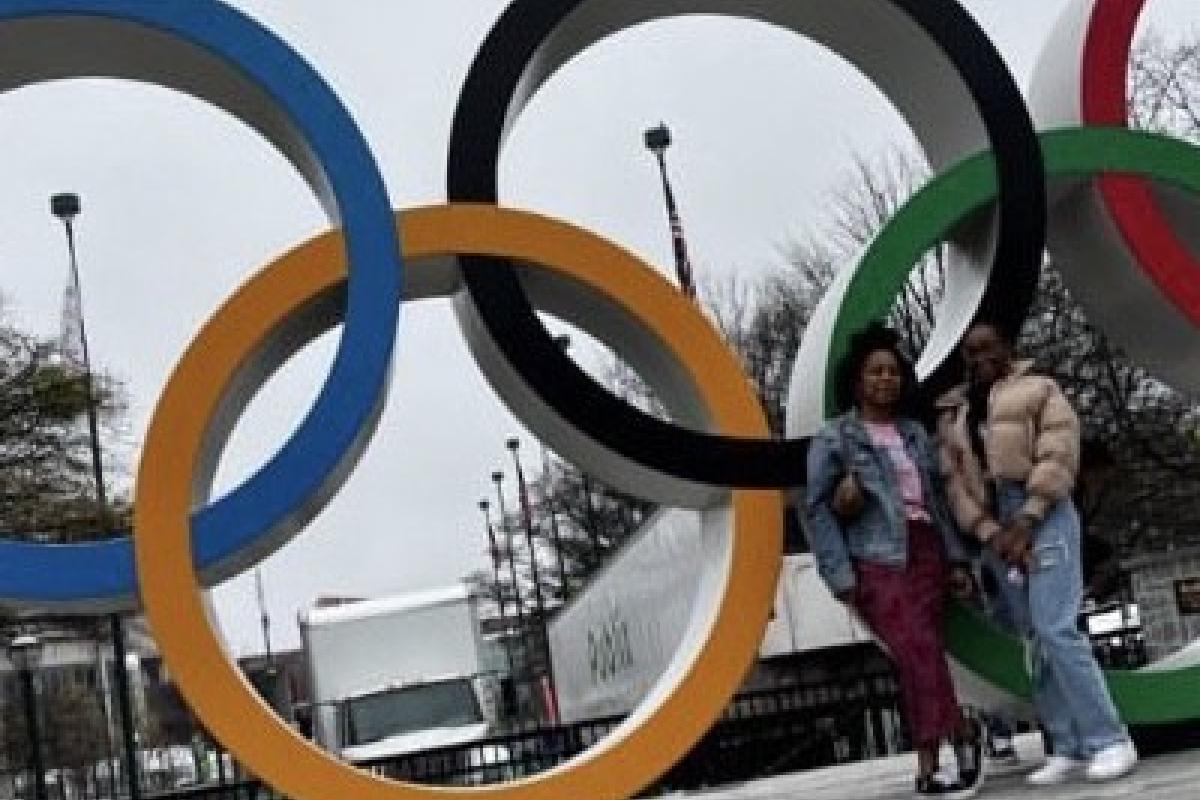 two students in front of the Olympic rings