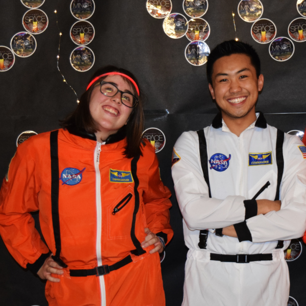 Two Course Assistants posing in front of Moonwalk banner