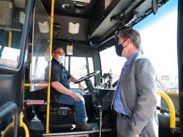 Pictured are COO Patrick O’Rourke and bus driver Carlos Baca speaking on campus.