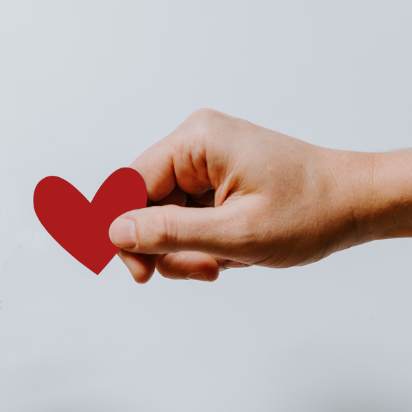 Hand holding small red heart