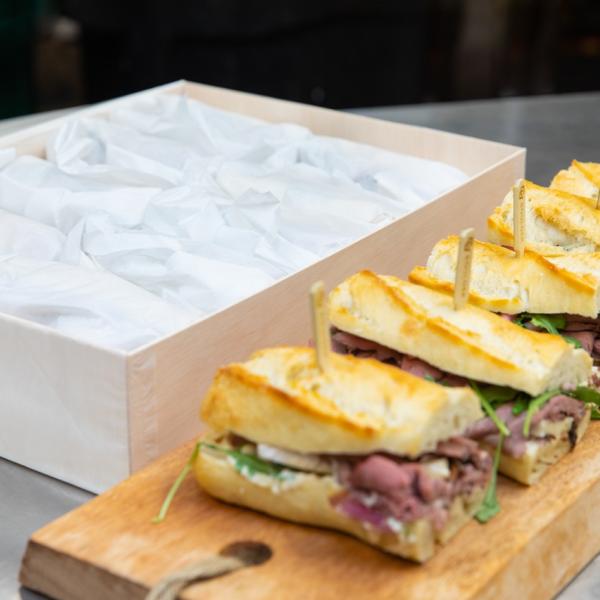 Row of sandwiches on wood plank