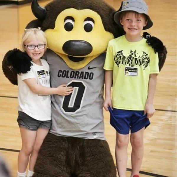 two kids smiling with chip in gym
