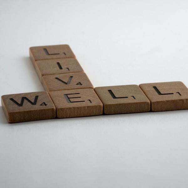 Scrabble tiles spelling out "Live Well"