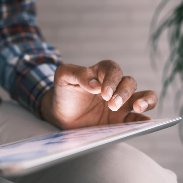 View of person from waist down holding a tablet