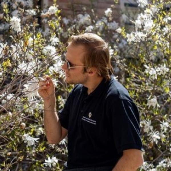 Guy smelling white flowers