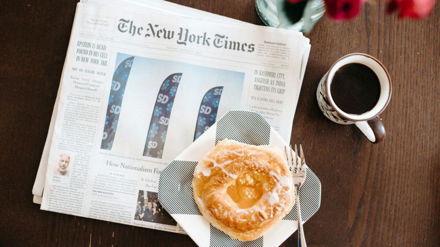 newspaper with a cup of coffee on a table