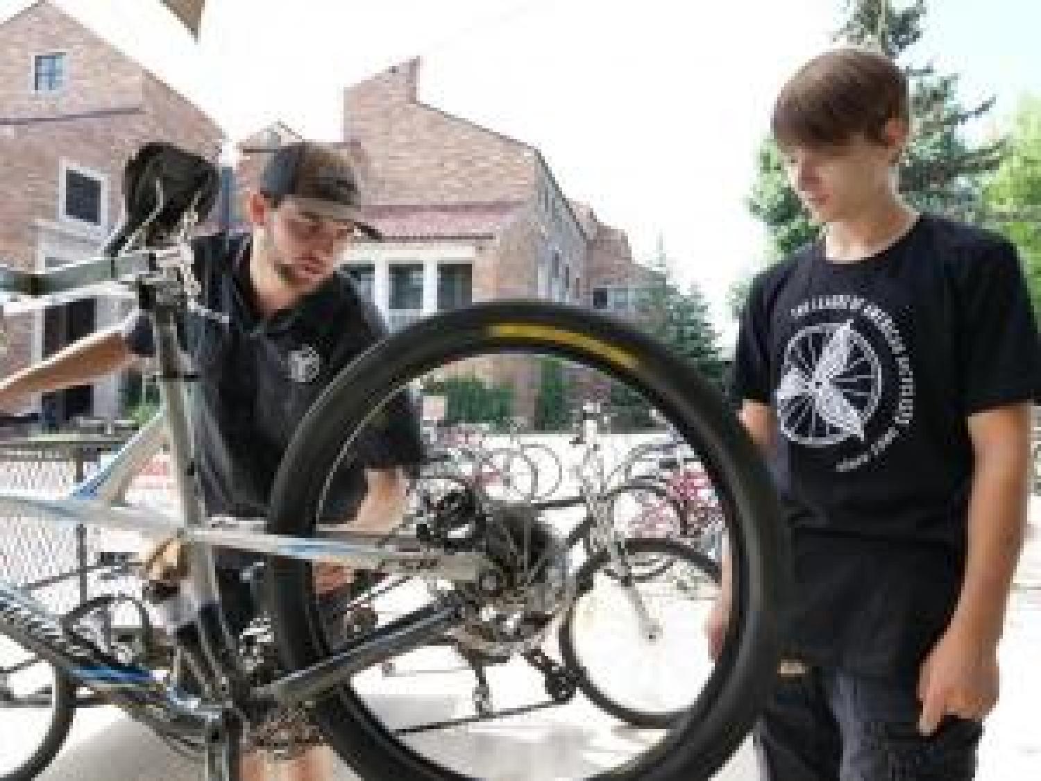 CU bike mechanic working on bike with student