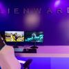 Gaming Chair and dual monitors in a pink and purple lit room with "Alienware" on wall