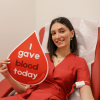 Woman donating blood with sign saying "I gave blood today"