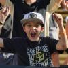 A young male fan in a crowd loudly cheering for CU