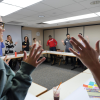 Group of people standing in a circle with jazz hands