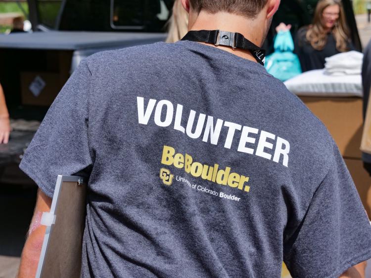 A CU Boulder staff member wearing a volunteer shirt during move-in week