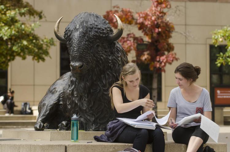 students talking outside on a bench